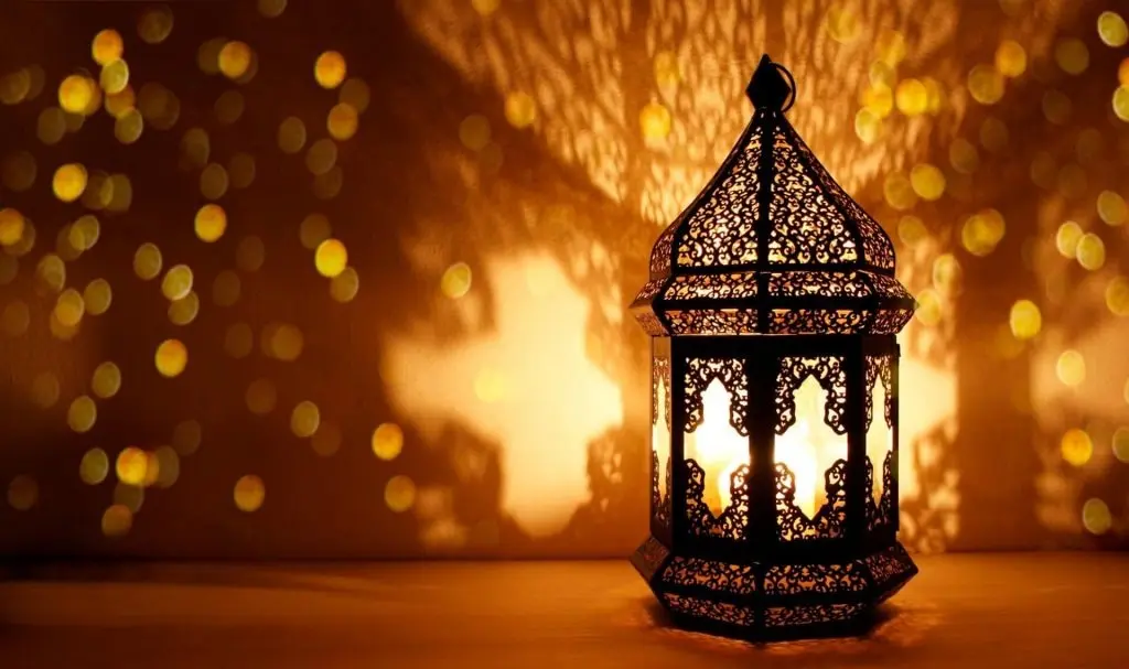 Ornamental Arabic lantern with burning candle and golden bokeh. Festive Islamic greeting.Our online Quran courses